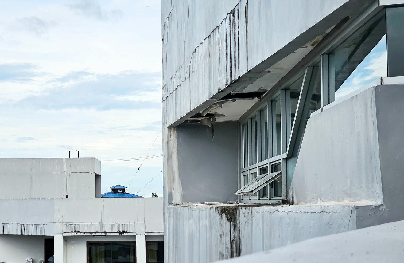 Detail of old residential flat apartment building exterior. Damaged roof with hole in ceiling. moldy ceiling